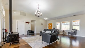 A spacious living room with a fireplace, dark wood flooring, and modern furniture.