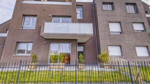 Un moderno edificio residenziale a più piani con tetto piatto, ampie finestre e un balcone.