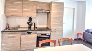 Una cucina moderna con mobili in legno, forno integrato e macchina da caffè.