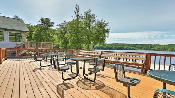 Une terrasse en bois avec des sièges extérieurs et une vue sur un lac.