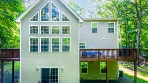 Une maison à deux étages avec un balcon, une véranda et un garage.