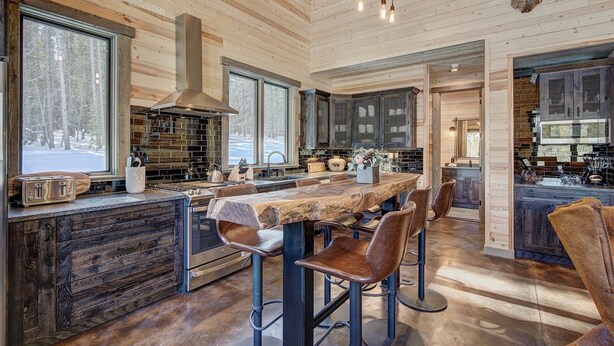 Una cocina moderna con una isla grande, armarios de madera y encimera de piedra.