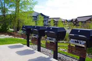 Des barbecues d’extérieur, une terrasse en béton et un quartier résidentiel avec des maisons en arrière-plan.