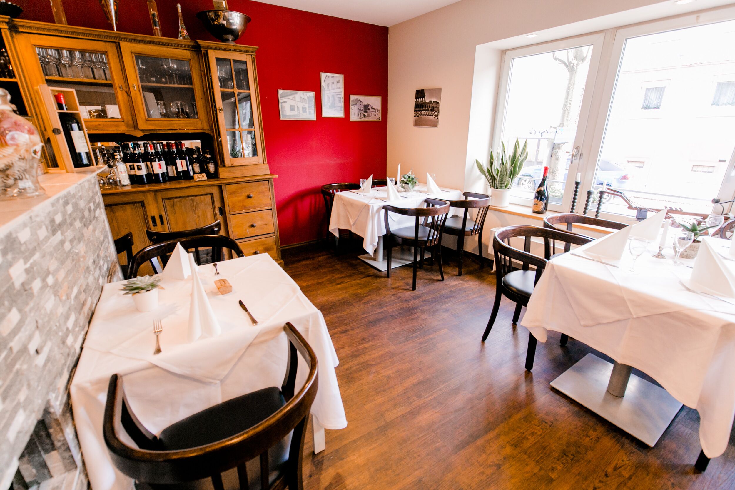Un restaurant avec des meubles en bois, des tables et des chaises blanches.