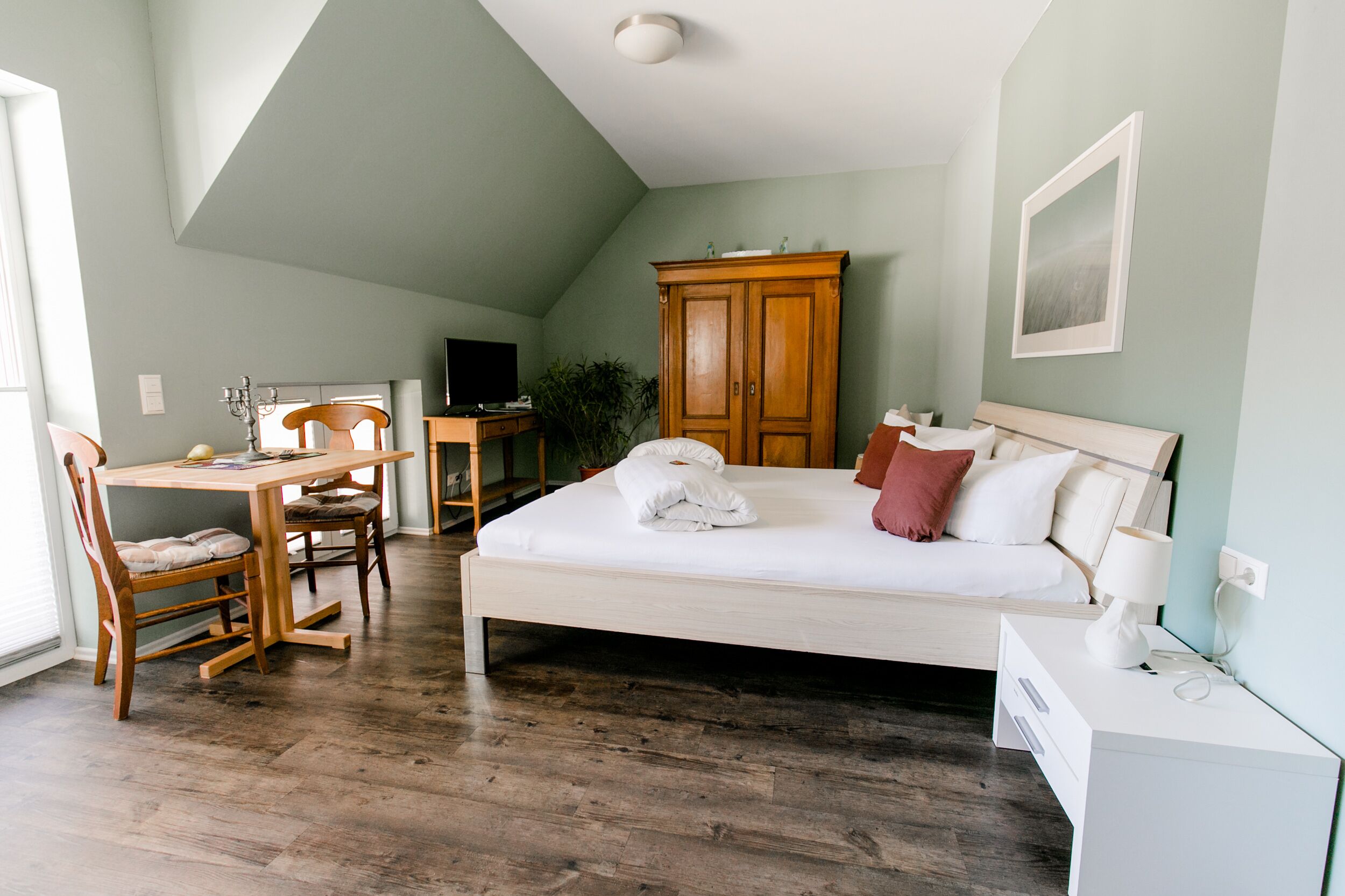 Un dormitorio con cama, escritorio, silla, armario y televisor.