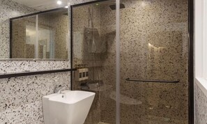 A bathroom with a white sink, a glass shower enclosure, and a marble backsplash. - Busan Lounge 26 Hotel (Busan)