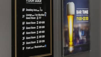 A wall with a floor guide and a lounge poster.