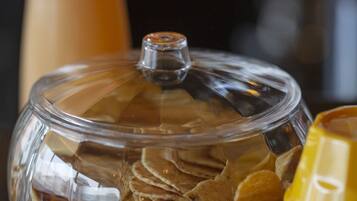 A glass container with snacks and condiments.