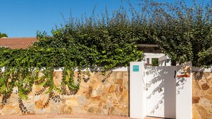 Un mur de pierre avec un portail blanc et une enseigne indiquant « ETV Villa Ragone ».
