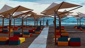 Uma praia com assentos e guarda-sóis coloridos.