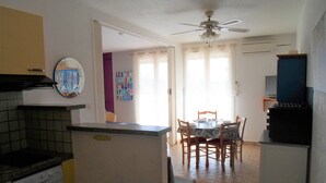 Una cocina compacta con comedor, ventilador de techo y piso de baldosas.