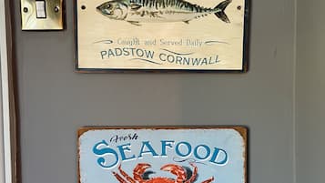 Two signs on a wall: one for a fresh fish market and another for a seafood market.