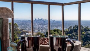 A balcony with two metal mugs, a cityscape view, and a clear sky. - Voted "Best Jet Liner Views" in LA Dogs Ok (Los Angeles)
