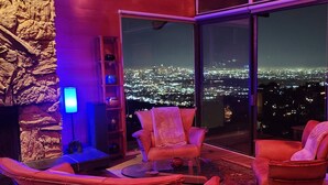 A modern living room with a city view, featuring leather sofas, a glass coffee table, and a stone accent wall. - Voted "Best Jet Liner Views" in LA Dogs Ok (Los Angeles)