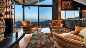 A spacious living area with leather sofas, a glass coffee table, and a large window offering a city view. - Voted "Best Jet Liner Views" in LA Dogs Ok (Los Angeles)