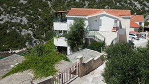 Un bâtiment à deux étages, doté d’un toit recouvert de tuiles rouges, d’un balcon et d’un escalier menant à l’étage supérieur.