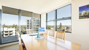Un comedor moderno con ventanas amplias, una mesa de madera y sillas.