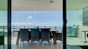 Un espace repas avec vue sur la mer, comprenant une table et des chaises.