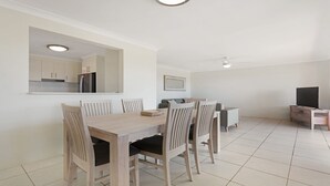 A modern apartment with a dining area, a living room, and a kitchen.