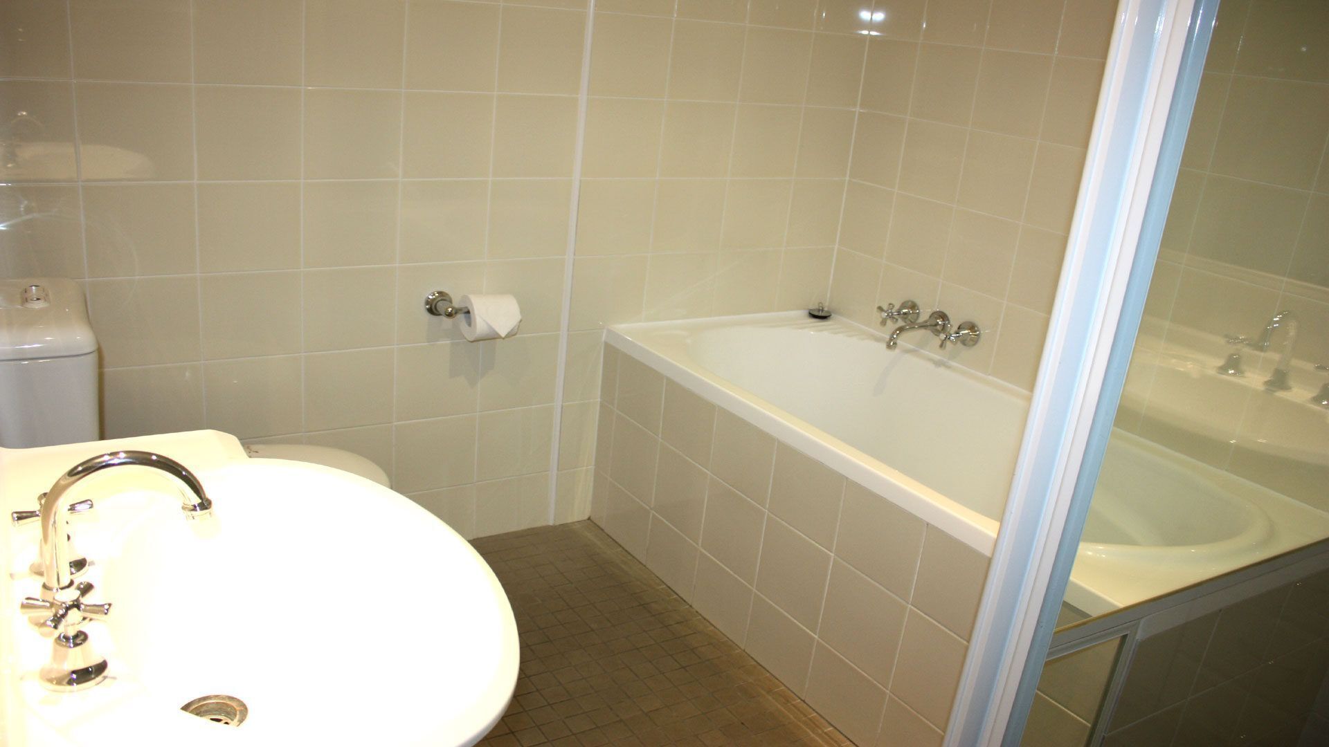 Une salle de bain avec une baignoire blanche, un lavabo et des toilettes.