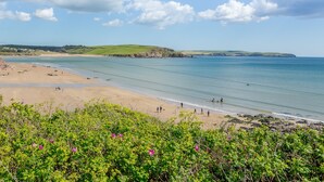 A coastal beach with clear waters, sandy shores, and green hills in the background. - Luxury property Sleeps 8 - Sea views & hot tub - 200m from beach! (Bigbury-on-Sea)
