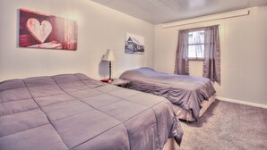 Une chambre avec deux lits, une table de chevet, une lampe et des œuvres d’art murales.