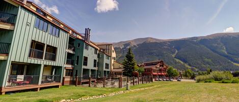 A multi-story hotel with balconies and a mountain view.