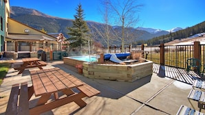A backyard with a hot tub, wooden deck, picnic table, and mountain views. - Fp209 Fox Pine Inn 1 Bedroom Condo by RedAwning (Copper Mountain)