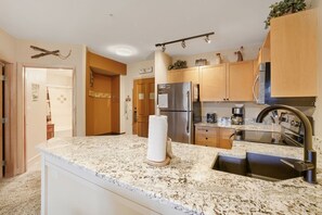 A kitchen with granite countertops, stainless steel appliances, wooden cabinets, and a built-in oven.