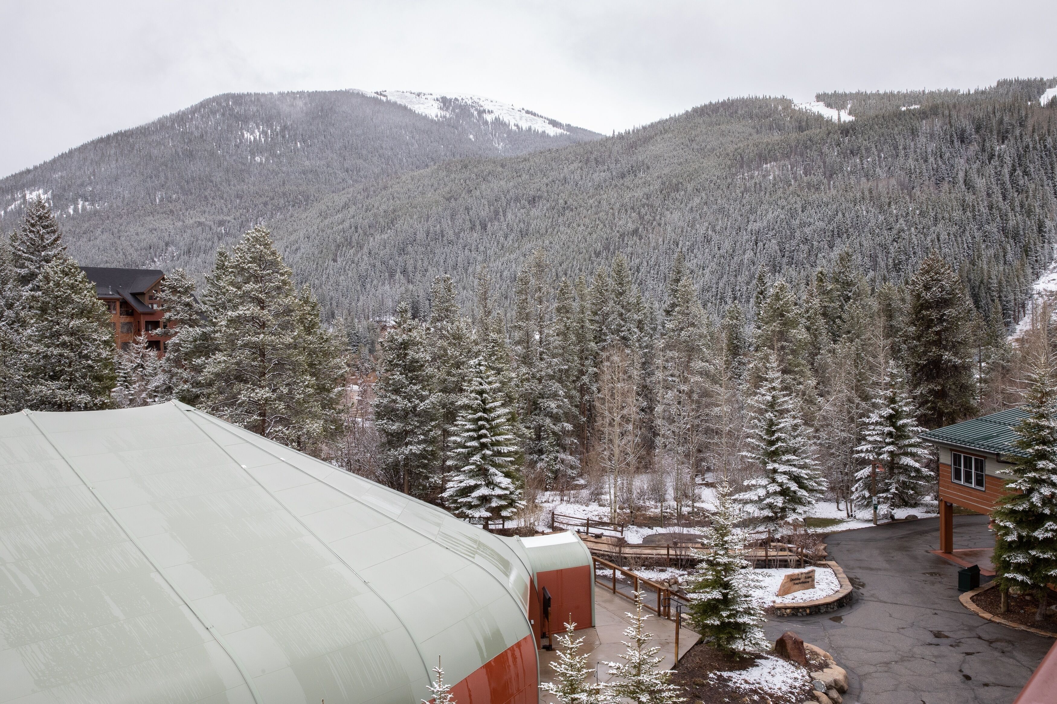A lodge with a snow-covered landscape, a mountain in the background, and a clear sky.