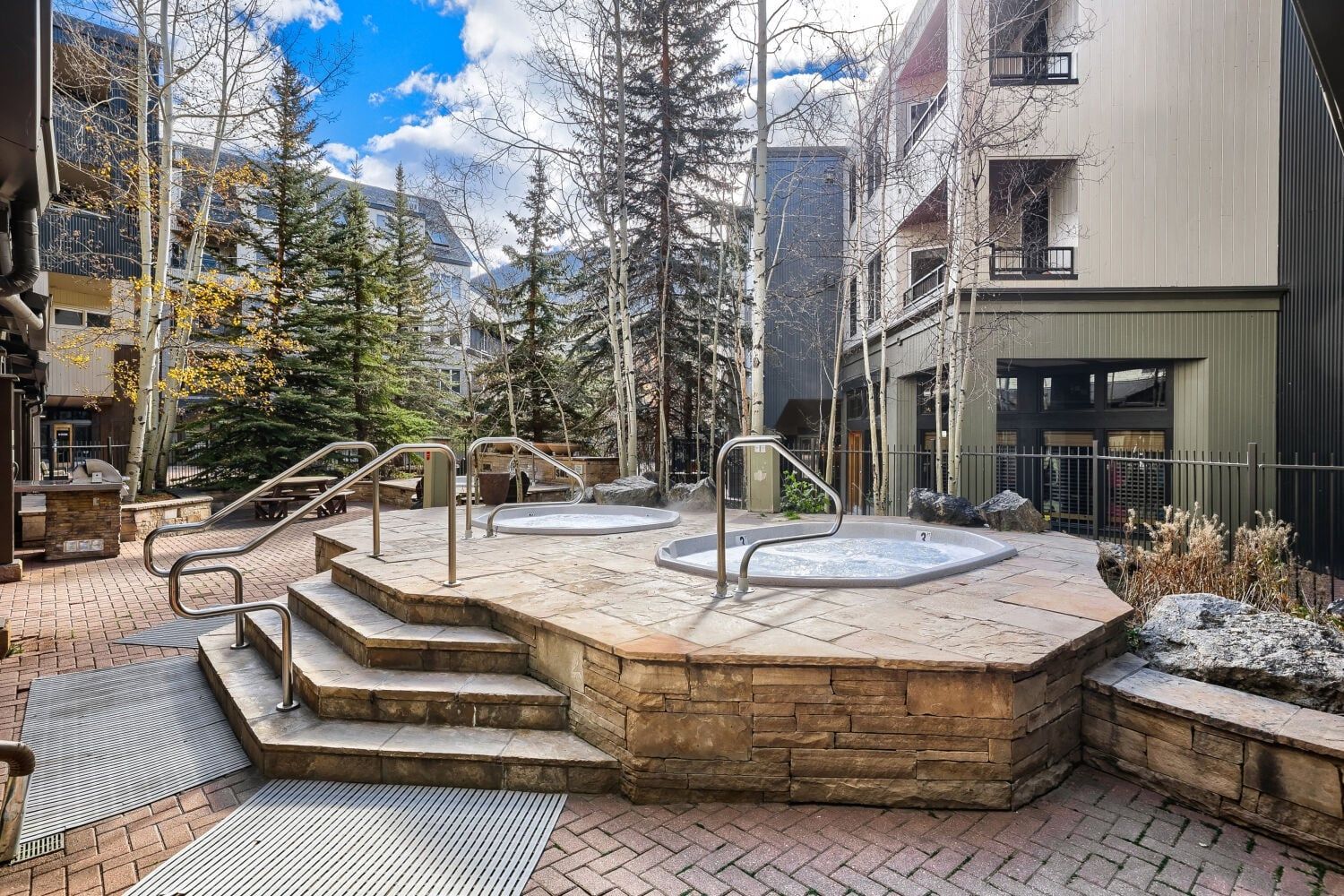 An outdoor spa area with hot tubs and stone steps.