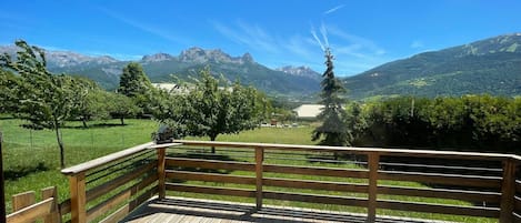 A wooden deck with a view of a mountainous landscape.