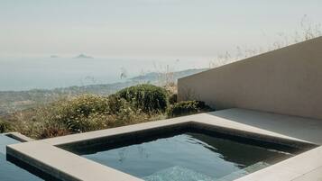 A modern outdoor pool with a clear view of distant hills and mountains.