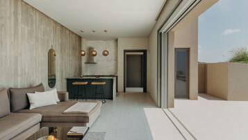 A modern interior with a sofa, a dining area, and a kitchen.