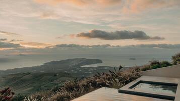 Una vista panorámica de un paisaje costero con una piscina infinita moderna con vistas al mar.