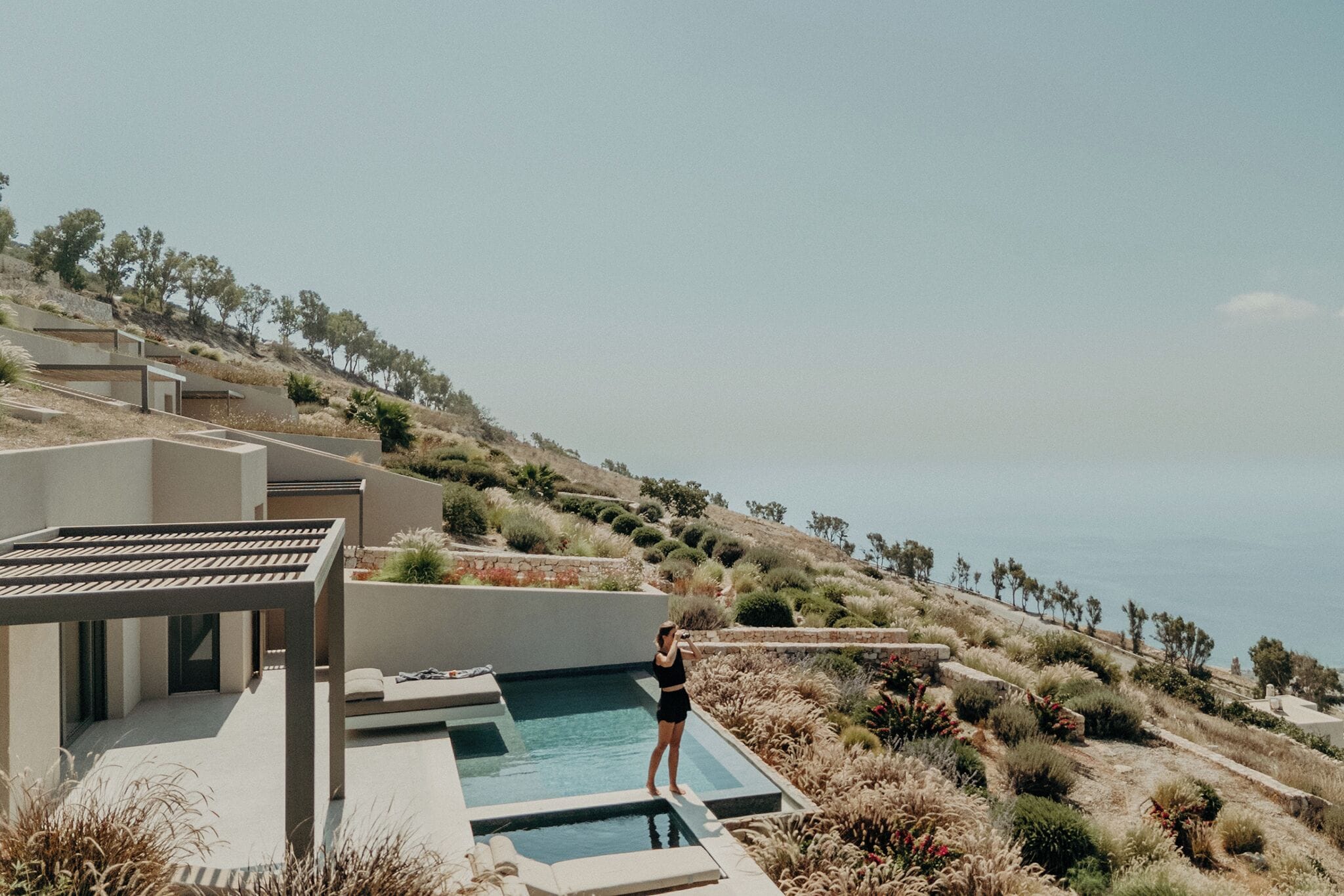 A modern outdoor pool area with a clear view of the surrounding landscape and distant horizon.