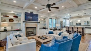 A spacious living room with a fireplace, white sofas, and blue armchairs. - 2 Minutes to Beach Club. Screened-in Porches, Bikes, Grill. Best Location! (Santa Rosa Beach)