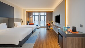 A modern hotel room with two beds, a desk, a TV, and a view of the city. - Holiday Inn Express Nanning Jiangnan by IHG (Nanning)