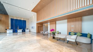A spacious lobby with a reception desk, seating area, and a modern ceiling design. - Holiday Inn Express Nanning Jiangnan by IHG (Nanning)