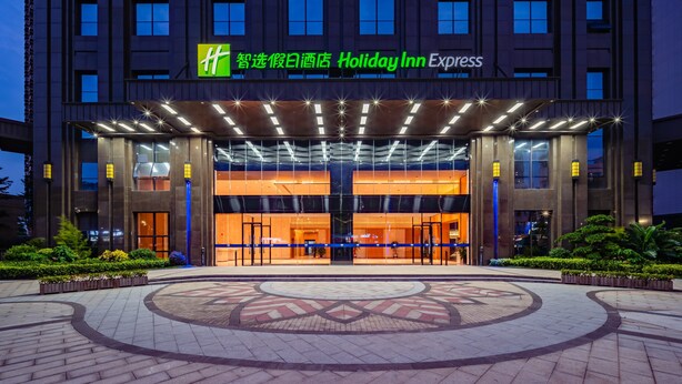A Holiday Inn Express hotel with a modern facade, large glass windows, and a well-lit entrance. - Holiday Inn Express Nanning Jiangnan by IHG (Nanning)