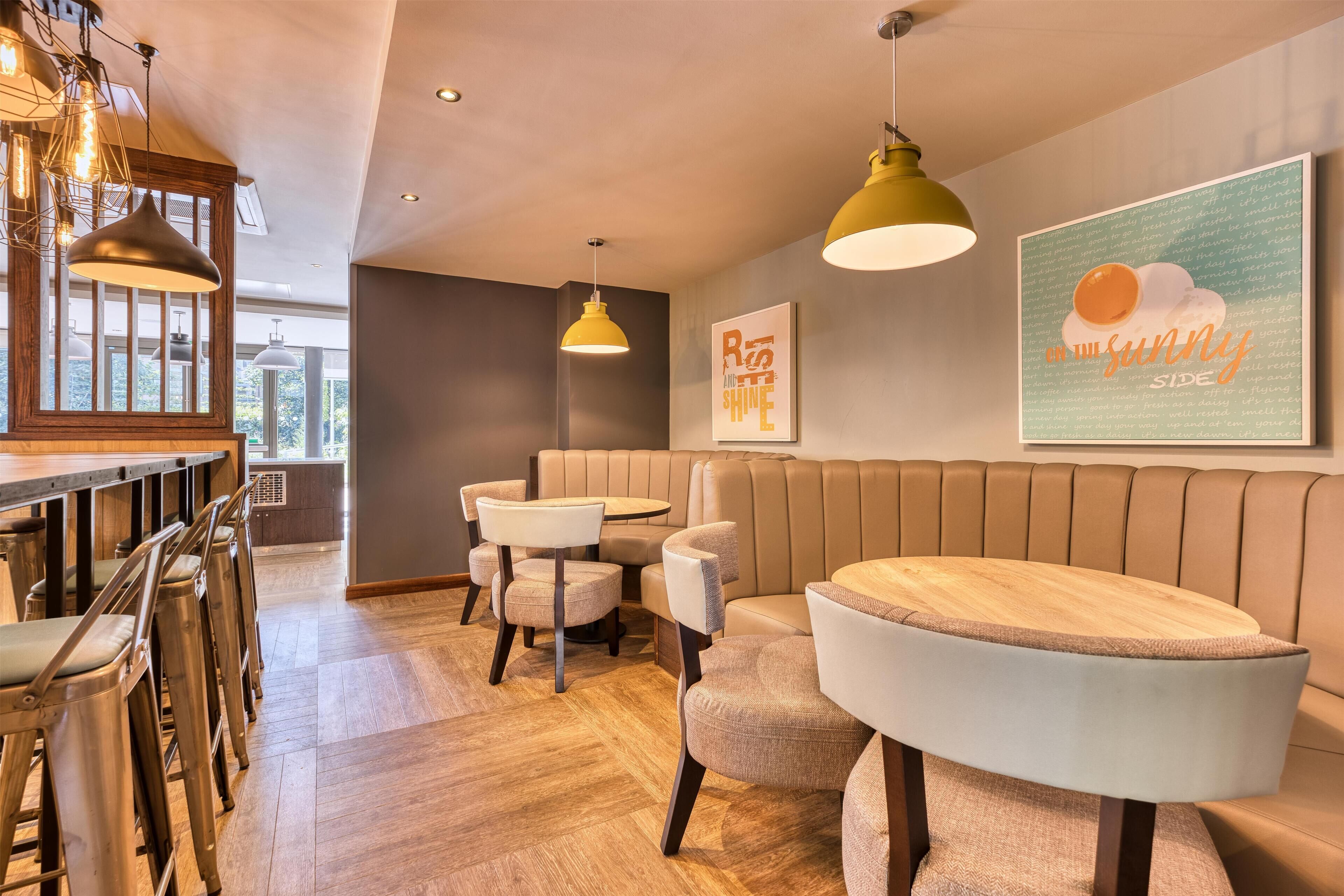 A modern interior with a bar area, seating, and a wall with a motivational quote.