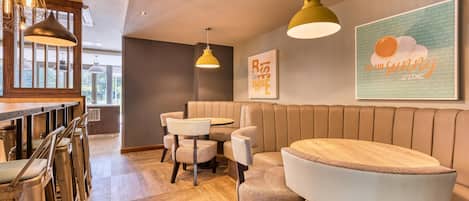 Ein modernes Interieur mit Bar, Sitzgelegenheiten und einer Wand mit einem Motivationsspruch.
