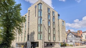 A modern building with a brick facade, large windows, and a corner entrance. - Premier Inn Oxford City Centre - Westgate (Oxford)