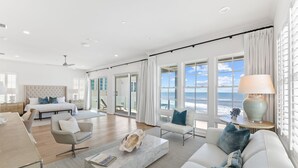 Un salon spacieux avec un grand lit, un canapé, une table basse et une vue sur l’océan.