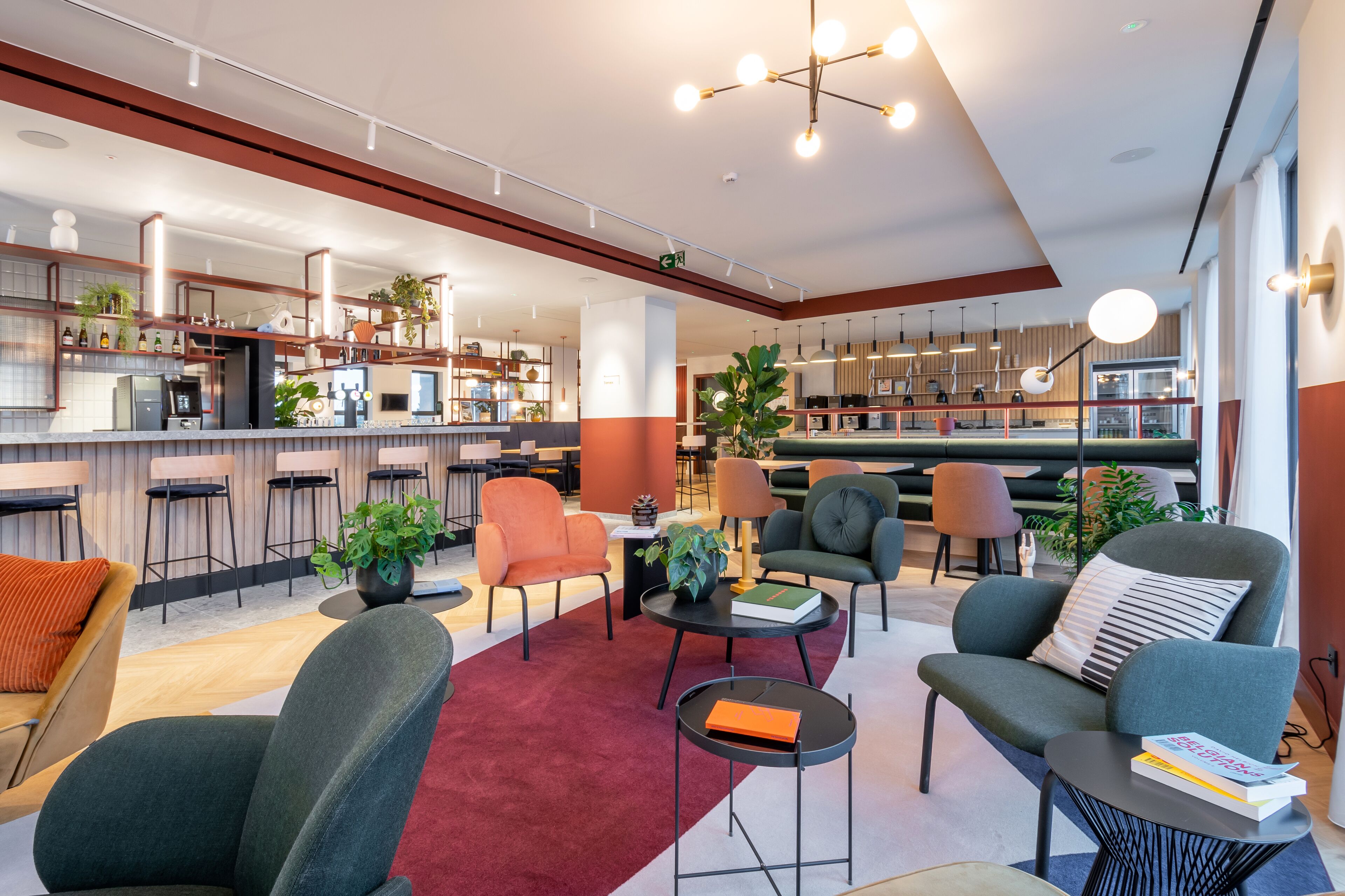 Een moderne lounge met zitplaatsen, een bar en een keuken op de achtergrond.