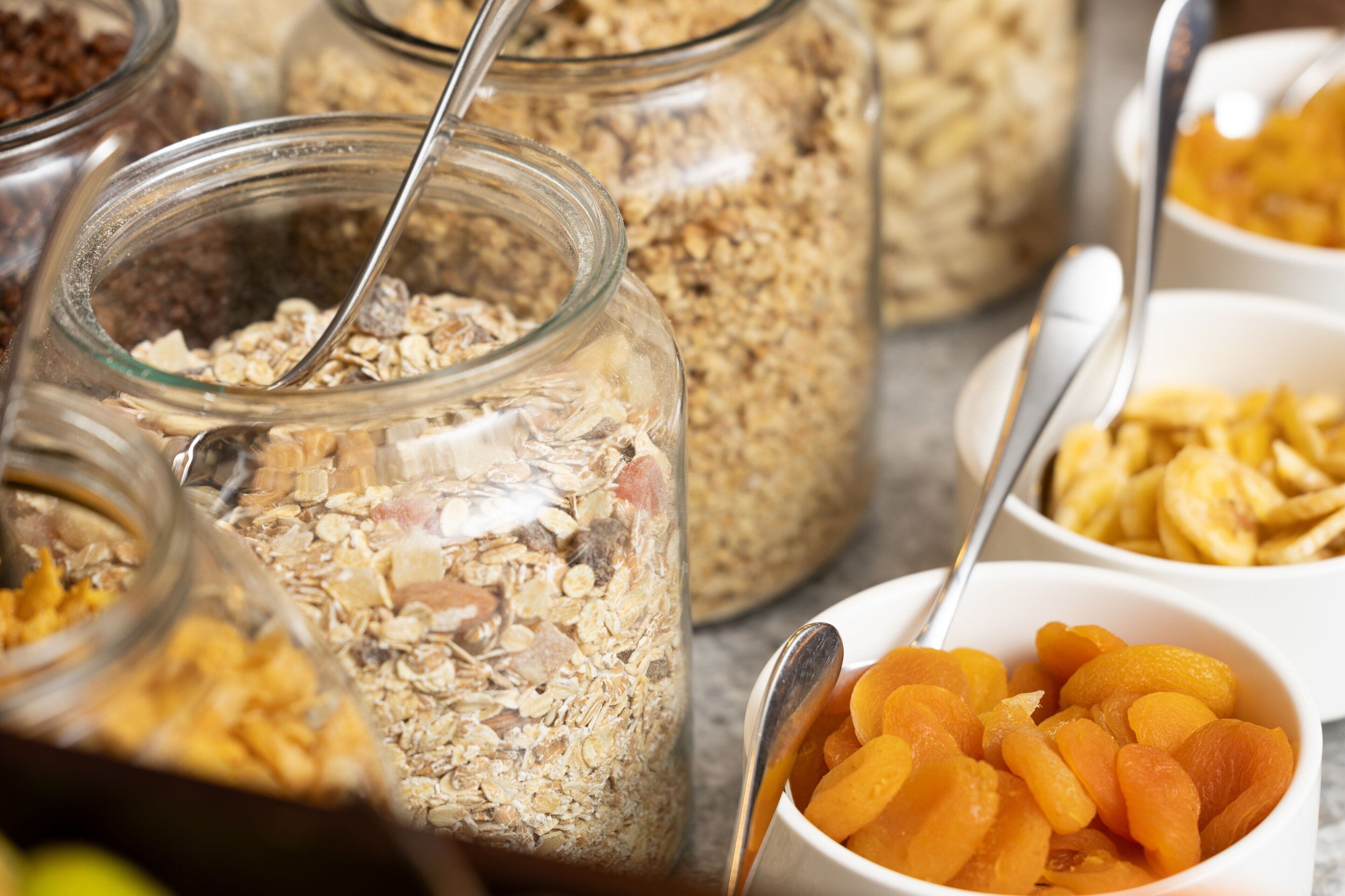 A variety of food items in jars and bowls, including granola and dried fruits.
