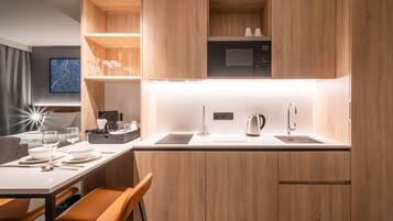 Una cocina moderna con armarios de madera, encimera blanca y microondas integrado.