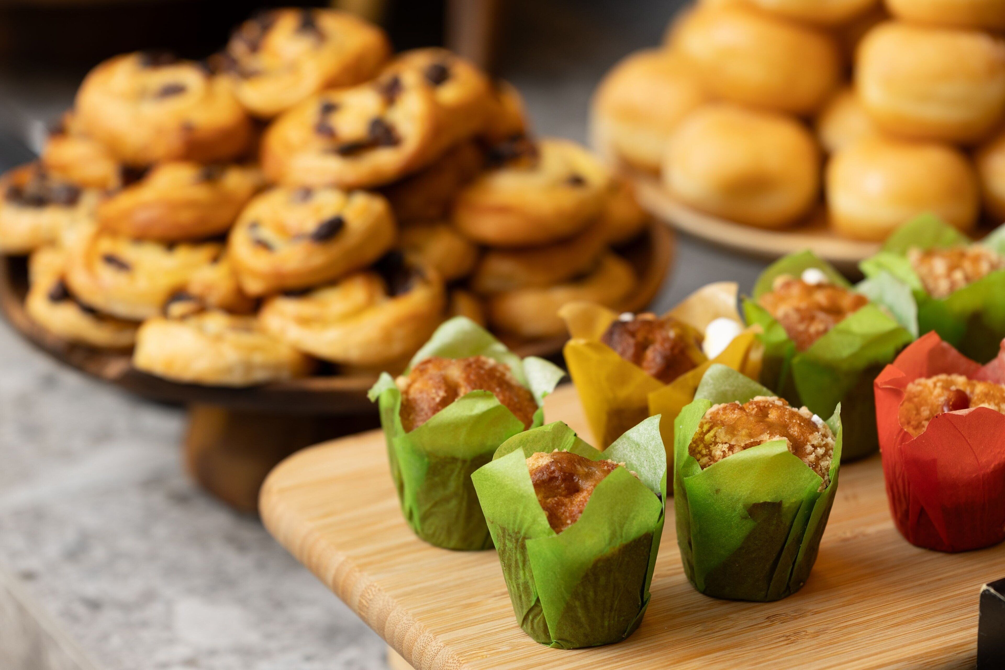 A variety of baked goods, including cookies and pastries, arranged on a wooden board.