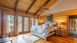 A log cabin bedroom with a bed, a nightstand, a lamp, and a ceiling fan. - Stunning Views | Spacious | Trail Access | Air Conditioning STR2025-060 (Ridgway)