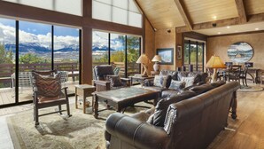 A spacious living room with a large window overlooking a mountainous landscape. - Mountain Retreat | Stunning Views | A/C | Hot Tub STR2025-062 (Ridgway)